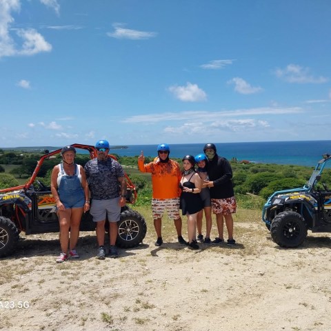 a group of people standing on a beach posing for the camera